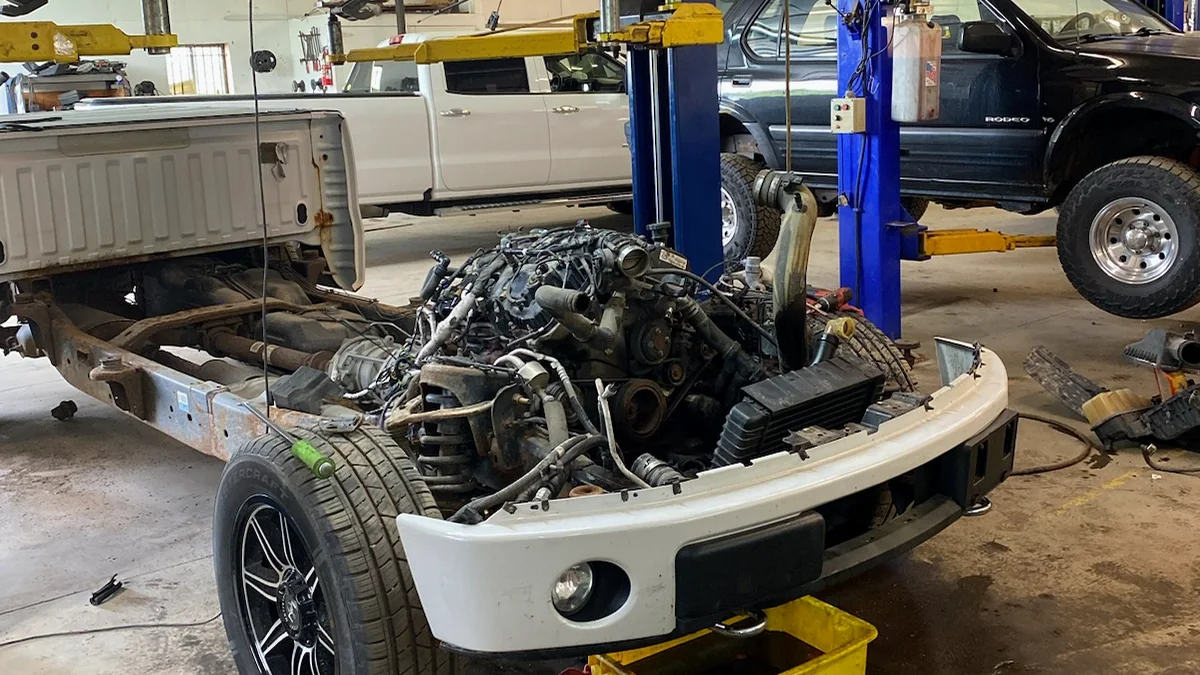 Vehicle engine and front assembly removed during major repair work
